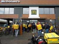 A McDonalds employee passes orders to Glovo food delivery couriers inside a restaurant, after the chain reopened amid Russias attack on Ukraine, in Kyiv, Ukraine September 20, 2022.  REUTERS/Valentyn Ogirenko