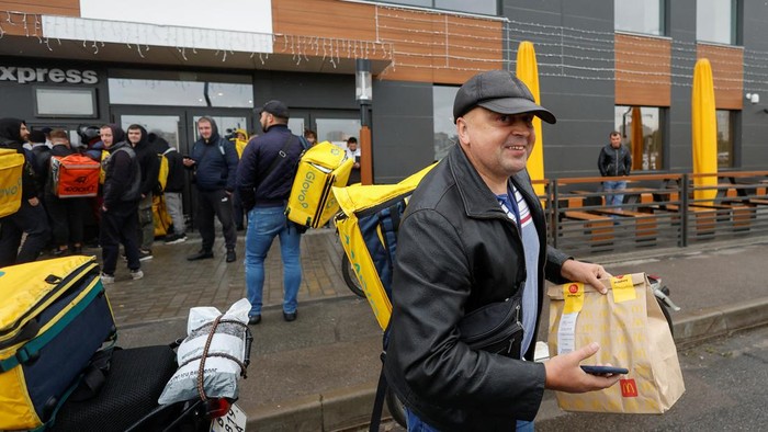 Potret McDonald's di Ukraina Buka Kembali, Pertama Kali Sejak Invasi Rusia A McDonald's employee passes orders to Glovo food delivery couriers inside a restaurant, after the chain reopened amid Russia's attack on Ukraine, in Kyiv, Ukraine September 20, 2022. REUTERS/Valentyn Ogirenko