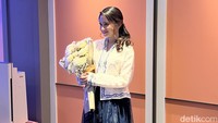 Sebagai atasan, dia mengenakan baju putih dengan aksen bordir biru bermotif floral. (Foto: Ron/detikcom)