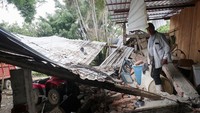 Seorang warga berjalan ke rumahnya yang rusak setelah gempa bumi pada hari Senin, di La Nuez, Michoacan, Meksiko. REUTERS/Henry Romero.