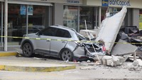 Mobil ringsek tertimpa puing bangunan yang roboh akibat gempa. REUTERS/Jesus Lozoya.