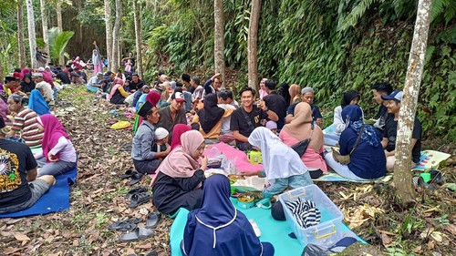Warga Lingkungan Kampung Saren Jawa, Karangasem, Bali, saat melaksanakan tradisi saparan dengan megibung di sumber mata air Kroya, Rabu (21/9/2022).