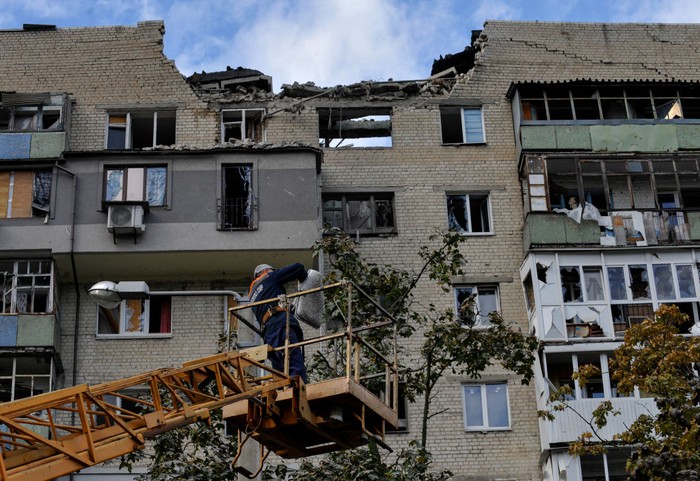 1243417346 KHARKIV, UKRAINE - 2022/09/21: People look at a partially destroyed residential building that was damaged as a result of a missile attack by the Russian army. Russia invaded Ukraine on 24 February 2022, triggering the largest military attack in Europe since World War II. (Photo by Sergei Chuzavkov/SOPA Images/LightRocket via Getty Images)