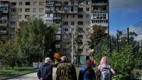 Warga lokal melihat apartemen setengah hancur yang terkena rudal Rusia di Kharkiv. Foto: SOPA Images/LightRocket via Gett/SOPA Images