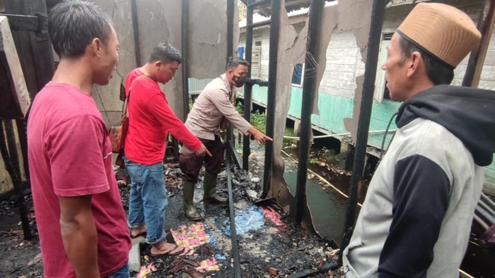 Personel Polres Inhil memasang garis polisi di lokasi kebakaran di Desa Bolak Raya, Indragiri Hilir, Riau. Dokumen Polres Inhil