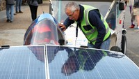 Pemimpin tim surya SolarFlair Afrika Selatan, Klasie Botha berinteraksi dengan pembalap Mangaliso Gxesha di V&A Waterfront, pada etape terakhir perlombaan Sasol Solar Challenge 2022.
