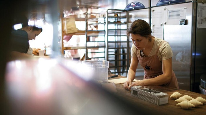 A member of staff works in the Sourdough Sophia bakery in London, Wednesday, Sept. 21, 2022. At the store, in the Crouch End neighbourhood of north London, the electricity bill has more than tripled since the start of the year according to owner Sophia Sutton-Jones, to roughly 5,500 pounds ($6,260) a month, up from 1,500 in January – a crushing increase that's making life difficult for the independent business. The bakery's woes underscore how energy price spikes are threatening companies, alongside a cost of living crisis afflicting Britain and much of Europe. (AP Photo/David Cliff)