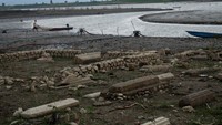 Warga berusaha mengalirkan air di area pemakaman lama di Waduk Gajah Mungkur yang mengalami penyusutan air di Wuryantoro, Kabupaten Wonogiri, Jawa Tengah, Rabu (21/9/2022).