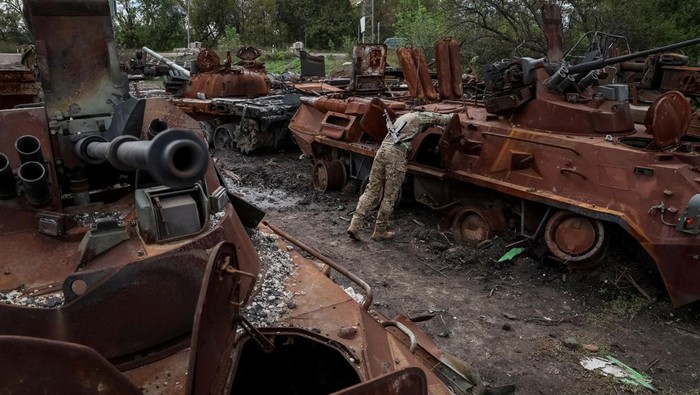 Penampakan Kuburan Kendaraan Tempur Rusia di Izium, Ukraina Ukrainian serviceman checks a destroyed Russian Armoured Personnel Carrier (APC), as Russia's attack on Ukraine continues, in the town of Izium, recently liberated by Ukrainian Armed Forces, in Kharkiv region, Ukraine September 20, 2022. REUTERS/Gleb Garanich TPX IMAGES OF THE DAY