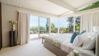 Kamar tidur utama yang tenang memiliki jendela kaca dan atap miring, menciptakan suasana yang terang. Foto: Dok. Neue Focus for Sothebys International Realty