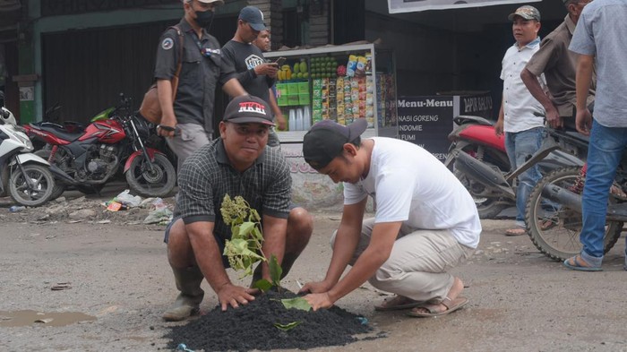 Warga Labuhanbatu melakukan aksi tanam pohon di jalan rusak. (Foto: Istimewa)