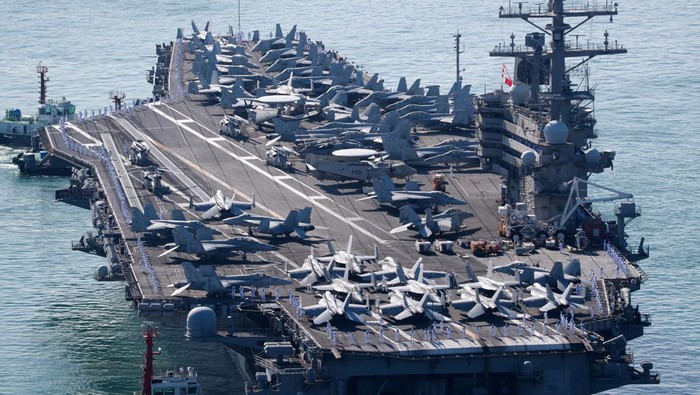 Bawa Jet-jet Tempur, USS Ronald Reagan Berlabuh di Busan, Ada Apa? Fighter jets sit on the deck of U.S. Navy aircraft carrier USS Ronald Reagan which is anchored at a port in Busan, South Korea, September 23, 2022. Yonhap via REUTERS ATTENTION EDITORS - THIS IMAGE HAS BEEN SUPPLIED BY A THIRD PARTY. SOUTH KOREA OUT. NO RESALES. NO ARCHIVE.
