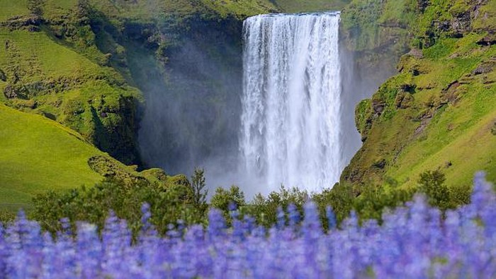 SKOGAR, ICELAND - SEPTEMBER 02: Tourists walk around Skogafoss waterfall on September 2, 2018 near Skogar, in South Iceland.