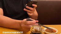Momennya saat makan di restoran Jepang juga terlihat di foto ini. Difoto candid ia sambil memainkan handphone dan meracik bumbu. Foto: Instagram