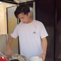 Dimas yang mengenakan kaos putih itu tampak dengan sigap langsung menyiapkan sendiri bakso jualannya. Ia pun terlihat ramah kepada pembeli baksonya tersebut. Foto: TikTok/@montcan