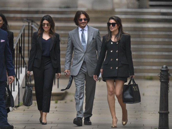US actor Johnny Depp (C) leaves with members of his team after day eight of his libel trial against News Group Newspapers (NGN) at the High Court in London, on July 16, 2020. - Depp is suing the publishers of The Sun and the author of the article for the claims that called him a 