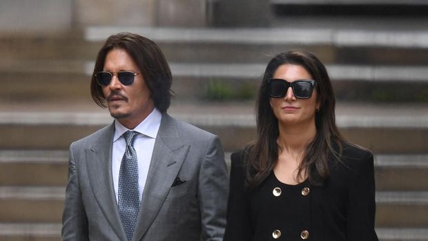 US actor Johnny Depp (L) leaves with members of his team after day eight of his libel trial against News Group Newspapers (NGN) at the High Court in London, on July 16, 2020. - Depp is suing the publishers of The Sun and the author of the article for the claims that called him a 