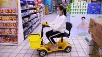 Seorang warga menaiki kereja belanda saat berbelanja di supermarket di Xi an, provinsi Shaanxi, China, Kamis (22/9/2022).