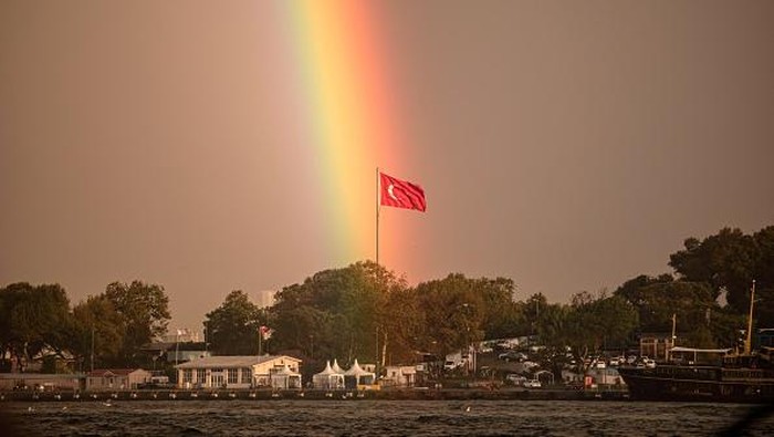 ISTANBUL, TURKEY - 2022/09/22: A rainbow is seen in the sky with the passengers boarding the city lines ferry at Eminonu pier. The rainbow seen in the sky in Istanbul created a beautiful image and some citizens took pictures with their mobile phones. (Photo by Onur Dogman/SOPA Images/LightRocket via Getty Images)