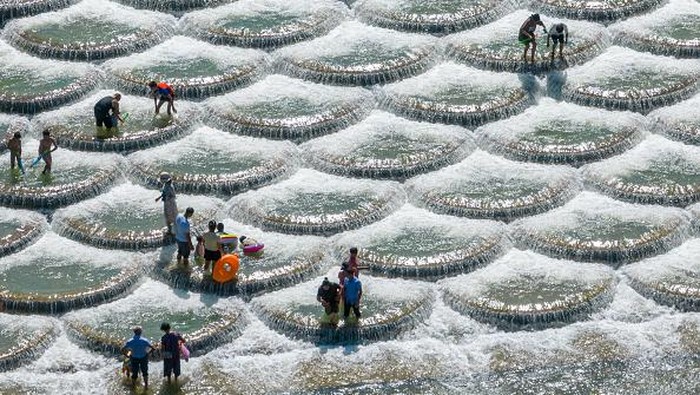 XIANFENG, CHINA - JULY 28: Tourists cool off at a location known for fish scale-shaped barriers that form small waterfalls during a hot summer day on July 28, 2022 in Xianfeng County, Enshi Tujia and Miao Autonomous Prefecture, Hubei Province of China. (Photo by Ye Xingjian/VCG via Getty Images)