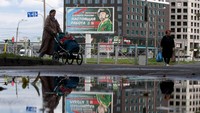 Sebuah papan iklan yang mempromosikan dinas militer kontrak dengan gambar seorang prajurit dan slogan bertuliskan Melayani Rusia adalah pekerjaan nyata duduk di Saint Petersburg. (Olga Maltseva/AFP/Getty Images)