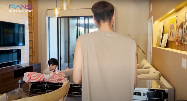 Tepat di sebelah sofa ruang TV terdapat sebuah meja panjang unik yang berbahan stainless. Ruang televisinya itu juga tampak nyaman dengan dilengkapi karpet coklat. Foto: YouTube/Rans Entertainment