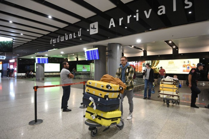 Russians arrive at Yerevans Zvartnots airport on September 21, 2022. - Flights out of Russia were nearly fully booked this week, airline and travel agent data showed on September 21, after President Vladimir Putin introduced a partial draft of reservists to fight in Ukraine. Defence Minister Sergei Shoigu said that Russia would initially mobilise some 300,000 reservists, after Putin in a televised address warned Russia would use all available military means in Ukraine. Direct flights to cities in nearby ex-Soviet countries of Armenia, Georgia, Azerbaijan and Kazakhstan were all sold out for Wednesday, the Aviasales website popular in Russia showed. (Photo by Karen MINASYAN / AFP) (Photo by KAREN MINASYAN/AFP via Getty Images)