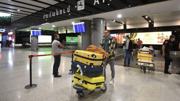 Russians arrive at Yerevans Zvartnots airport on September 21, 2022. - Flights out of Russia were nearly fully booked this week, airline and travel agent data showed on September 21, after President Vladimir Putin introduced a partial draft of reservists to fight in Ukraine. Defence Minister Sergei Shoigu said that Russia would initially mobilise some 300,000 reservists, after Putin in a televised address warned Russia would use all available military means in Ukraine. Direct flights to cities in nearby ex-Soviet countries of Armenia, Georgia, Azerbaijan and Kazakhstan were all sold out for Wednesday, the Aviasales website popular in Russia showed. (Photo by Karen MINASYAN / AFP) (Photo by KAREN MINASYAN/AFP via Getty Images)