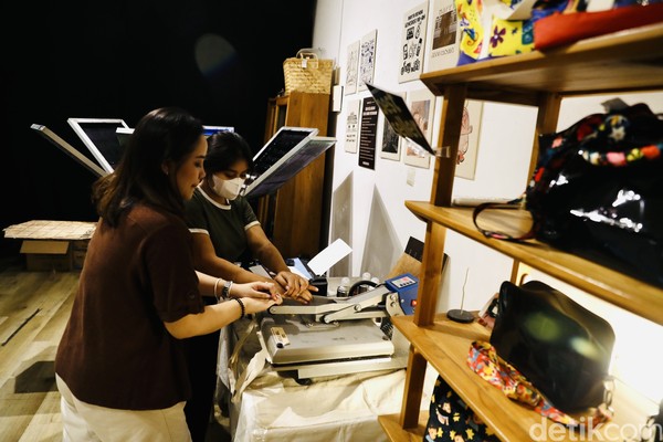 Beginilah serunya saat desain custom pengunjung dipress agar menempel di produk. Foto: Rengga Sancaya/detikcom Beginilah serunya saat desain custom pengunjung dipress agar menempel di produk. Foto: Rengga Sancaya/detikcom