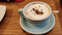 Ingin memberi taburan serbuk cokelat, barista ini tak memeriksa bubuk cokelatnya terlebih dahulu. Akibat bubuk cokelat yang menggumpal, latte ini terlihat seperti tertumpah gundukan tanah di tengahnya. Foto: Lets Eat Cake