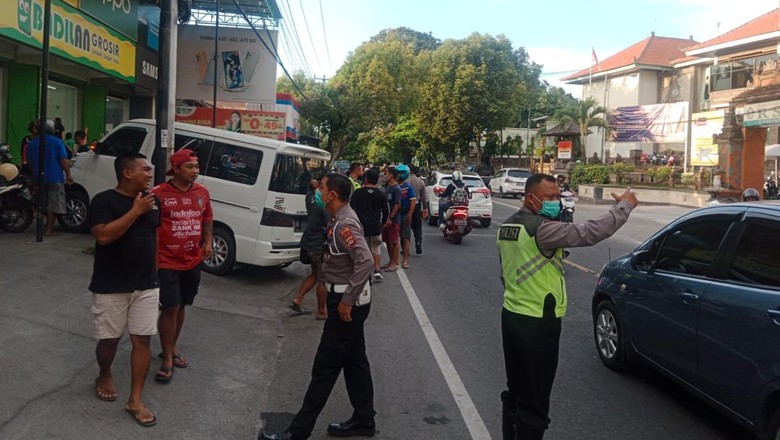 Polisi saat mengamankan WNA Jerman, Class Riese (56), yang diduga merampas mobil milik warga di Jalan Ngurah Rai, tepatnya di depan RSUD Buleleng, Kabupaten Buleleng, Bali, Jumat (23/9/2022).