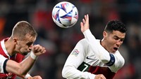 Cristiano Ronaldo juga sempat terlihat menahan bola dengan tangannya karena berusaha melindungi hidungnya yang terluka. Foto: Getty Images/Thomas Eisenhuth