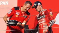 Kehadiran Jack Miller di podium tak lengkap rasanya tanpa aksi shoey. Nih, sampanye pun sudah siap dituang ke dalam sepatunya. Foto: AFP via Getty Images/TOSHIFUMI KITAMURA