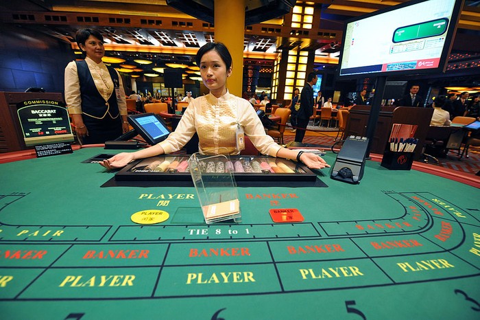 A dealer stands by a table at the opening of Singapores first casino, the Resorts World Sentosa complex, in Singapore on February 14, 2010. Singapores first casino opened for business when the first punter was allowed into the gaming section of Resorts World Sentosa complex. The opening -- to be followed within months by a second casino resort -- is part of a multi-billion-dollar effort to transform Singapores tourism industry. AFP PHOTO/ROSLAN RAHMAN (Photo credit should read ROSLAN RAHMAN/AFP via Getty Images)