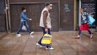 Pejalan kaki melewati toko-toko yang tutup di kota Stoke-on-Trent. Kota ini terkena dampak resesi yang paling parah. Foto: Getty Images/Busà Photography