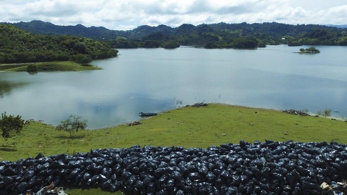 El Salvador Plastic Waste Garbage floats on the basin of the Cerron Grande hydroelectric dam near Potonico, El Salvador, Sunday, Sept. 25, 2022. Recent rains threw large quantities of garbage into the basin. (AP Photo/Salvador Melendez)