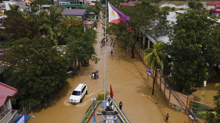 Foto Udara Banjir di Filipina Akibat Topan Super Noru In this image taken with a drone, vehicles pass by a flooded road due to Typhoon Noru in San Miguel town, Bulacan province, Philippines, Monday, Sept. 26, 2022. Typhoon Noru blew out of the northern Philippines on Monday, leaving some people dead, causing floods and power outages and forcing officials to suspend classes and government work in the capital and outlying provinces. (AP Photo/Aaron Favila)