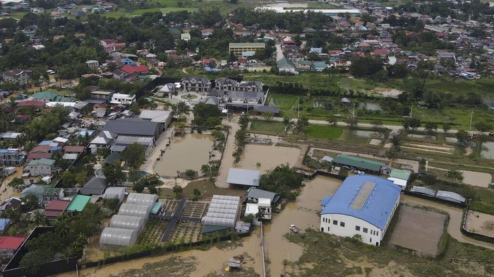In this image taken with a drone, vehicles pass by a flooded road due to Typhoon Noru in San Miguel town, Bulacan province, Philippines, Monday, Sept. 26, 2022. Typhoon Noru blew out of the northern Philippines on Monday, leaving some people dead, causing floods and power outages and forcing officials to suspend classes and government work in the capital and outlying provinces. (AP Photo/Aaron Favila)