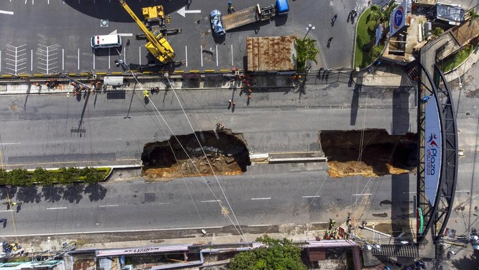 Lubang Raksasa Bermunculan Lagi di Tengah Jalan Guatemala A vehicle is pulled from a sinkhole in Villa Nueva, Guatemala, Sunday, Sept. 25, 2022. Rescuers are searching for people who are believed to have fallen into the sinkhole while driving their vehicle, while four others were rescued alive from the scene on Saturday night. (AP Photo/Moises Castillo)