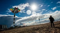 Seorang pria terlihat menerbangkan layang-layang raksasanya di sepanjang resor pantai Den Haag, Belanda, Minggu (25/9/2022) waktu setempat.  
