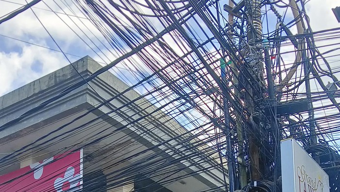 Penampakan sejumlah kabel di jalan Legian, Kuta Badung membuat pemandangan di kawasan ini makin semrawut, Senin (26/9/2022)