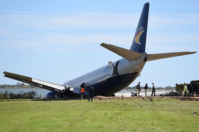 Pesawat tergelincir di Prancis Technicians and engineers work to remove an Aeropostale Boeing 737 cargo plane after it overrun the runway during its night landing phase at Montpellier airport, on September 25, 2022. - French authorities on September 24 closed the airport in the southern city of Montpellier for an indefinite period after a cargo plane overran the runway and ended up with its nose in a nearby lake. (Photo by Sylvain THOMAS / AFP) (Photo by SYLVAIN THOMAS/AFP via Getty Images)