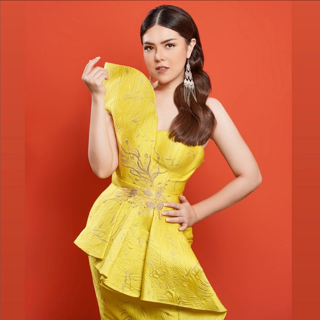 Bak model, Tina Toon berpose mengenakan gaun kuning dengan detail ruffle karya desainer Alfons Lee. Foto: Instagram/@tinatoon101 @yudajulianofficial
