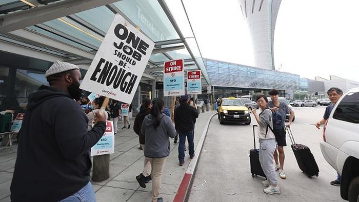 Biaya Hidup Tinggi, Pegawai Restoran di Bandara AS Tuntut Naik Gaji SAN FRANCISCO, CALIFORNIA - SEPTEMBER 26: A sign is posted on the front of a cafe inside the international terminal at San Francisco International Airport as union food service workers are on strike on September 26, 2022 in San Francisco, California. Nearly 1,000 Unite Here Local No. 2 food service union workers at San Francisco International Airport walked off the job and went on strike early Monday morning as they fight for better wages. Many of the workers have had to take on second jobs to support their families. (Photo by Justin Sullivan/Getty Images)