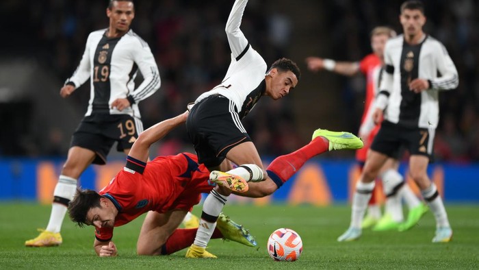 LONDON, ENGLAND - SEPTEMBER 26: Harry Maguire of England is tackled by Jamal Musiala of Germany during the UEFA Nations League League A Group 3 match between England and Germany at Wembley Stadium on September 26, 2022 in London, England. (Photo by Shaun Botterill/Getty Images)