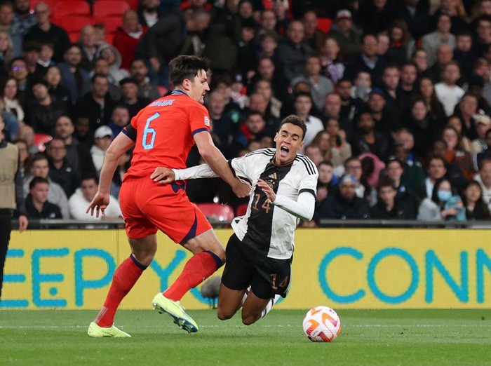 LONDON, ENGLAND - SEPTEMBER 26: Jamal Musiala of Germany is fouled by Harry Maguire of England leading to a penalty being awarded after a VAR review during the UEFA Nations League League A Group 3 match between England and Germany at Wembley Stadium on September 26, 2022 in London, England. (Photo by Julian Finney/Getty Images)