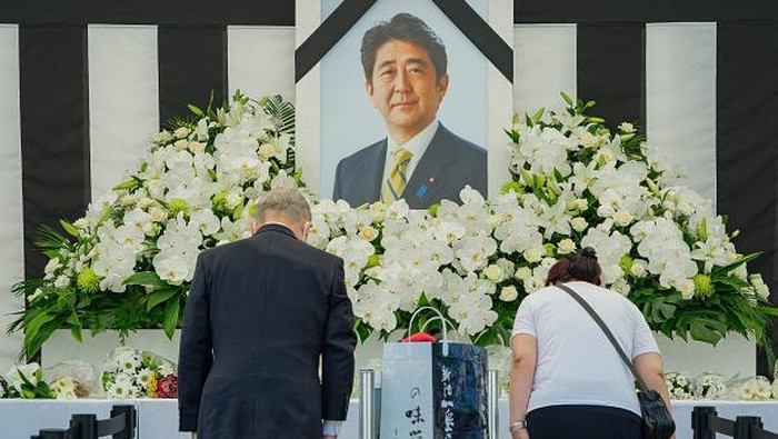 A police officer inspects a bush near the Nippon Budokan ahead of the state funeral for former Japanese prime minister Shinzo Abe in Tokyo on September 27, 2022. - Thousands of Japanese and foreign dignitaries have gathered in Tokyo on September 27 to honour Abe, at a rare state funeral that has sparked controversy and protest.