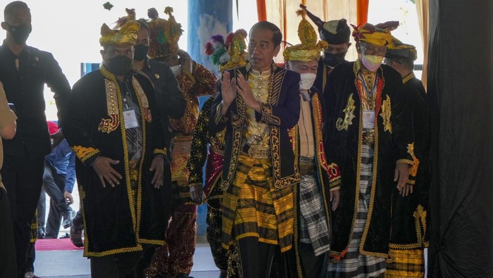 Presiden Joko Widodo (kedua kiri) mengenakan mahkota Kesultanan Buton serta pakaian adat saat prosesi penganugerahan gelar kehormatan di Keraton Buton, Baubau, Sulawesi Tenggara, Selasa (27/9/2022). Presiden dalam kunjungan kerjanya di Kepulauan Buton Sulawesi Tenggara dianugerahi gelar adat dan budaya bergelar La Ode Joko Widodo Lakina Bhawaangi Yi Nusantara dari Sultan Buton ke-40 sekaligus dinyatakan menjadi warga, kerabat serta sesepuh Kesultanan Buton. ANTARA FOTO/Jojon/rwa.
