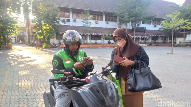 Pegawai tiba di Kantor Balai Kota Makassar menggunakan jasa ojek online.