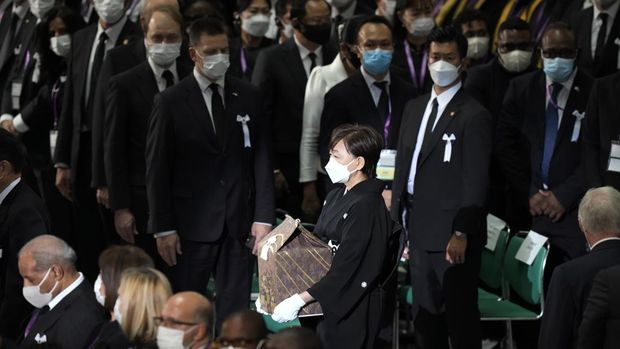 Istri mantan Perdana Menteri Jepang Shinzo Abe, Akie membawa abu suaminya saat tiba untuk memulai pemakaman kenegaraannya di Nippon Budokan di Tokyo, Jepang, Selasa (27/9/2022). Pemerintah Jepang menghabiskan biaya sebesar 1,65 miliar Yen (Rp 173 miliar) untuk pemakaman kenegaraan Abe, yang mencakup 800 juta Yen (Rp 83,9 miliar) untuk keamanan dan 600 juta Yen (Rp 62,9 miliar) untuk menjamu delegasi asing. (AP Photo/Eugene Hoshiko, Pool)